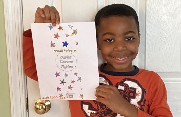 Boy holding a Junior Cancer Fighter artwork activity